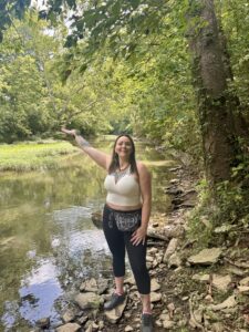 A girl stands by a creek on sacred ground near Adena Mound in Lexington, Kentucky